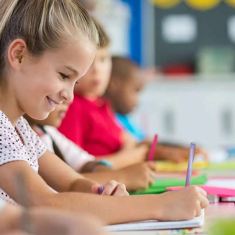 Young Asian girl sitting at a desk during a Scribble 2 Script session