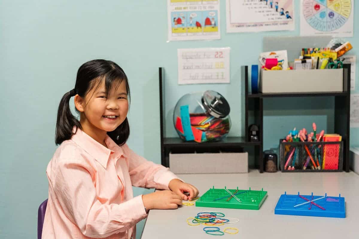 Young asian girl at a desk working on a puzzle