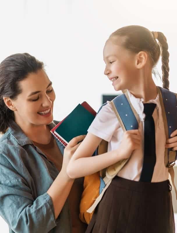 Happy family preparing for school. Little girl with mother.
