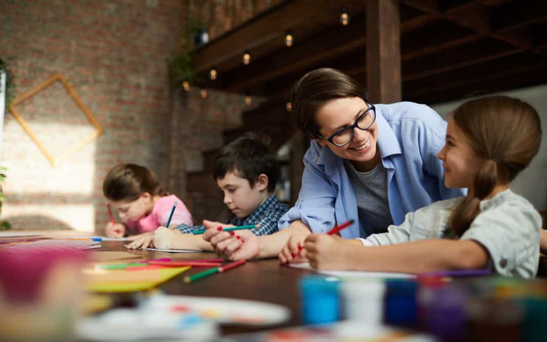 Portrait of smiling young woman working with kids in a class